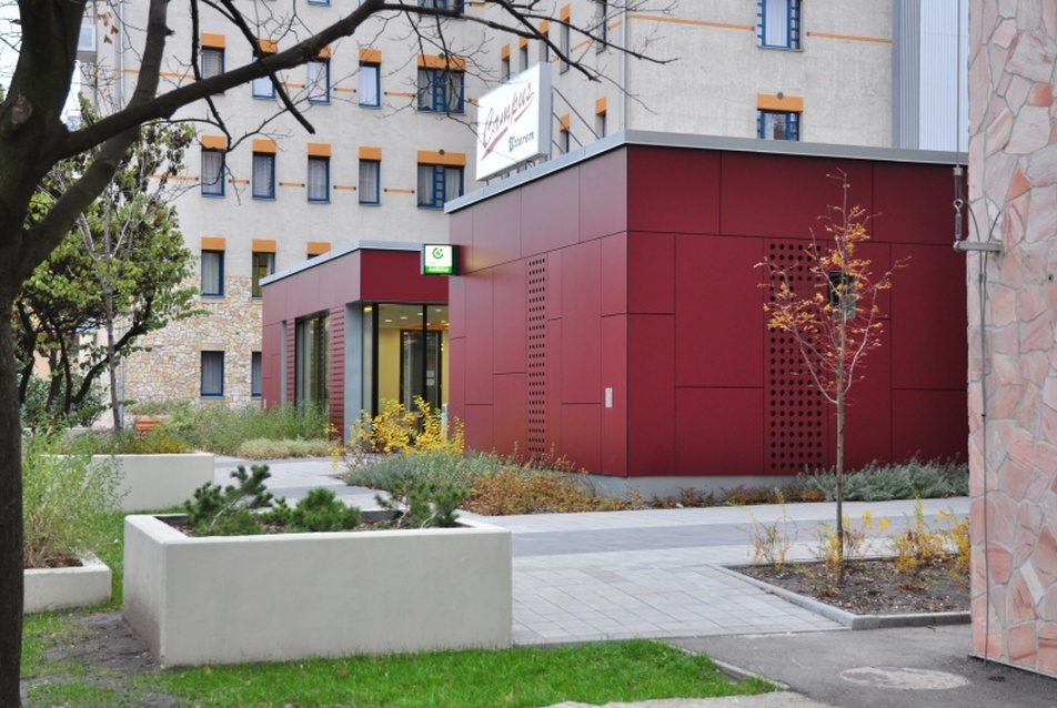 Kicsi, piros, kortárs épület a lakótornyok árnyékában: a Dunaújvárosi Főiskola menzája