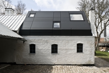 A korábbi pajta egyszerű falai mögött egy modern műhelystúdió jött létre. Tetőtéri ablakokkal és napkollektorokkal tarkított jellegzetes fekete alumíniumteteje egy kincsesládából előbukkanó drágakőre hasonlít.Fotó: VELUX
