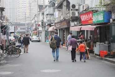 Sanghaj eredeti arcának egy általános utcai képe. A földszint szinte mindenhol nyitott, és különböző szolgáltatásokkal csábítja az utcán sétálókat, forrás: Gyergyák János