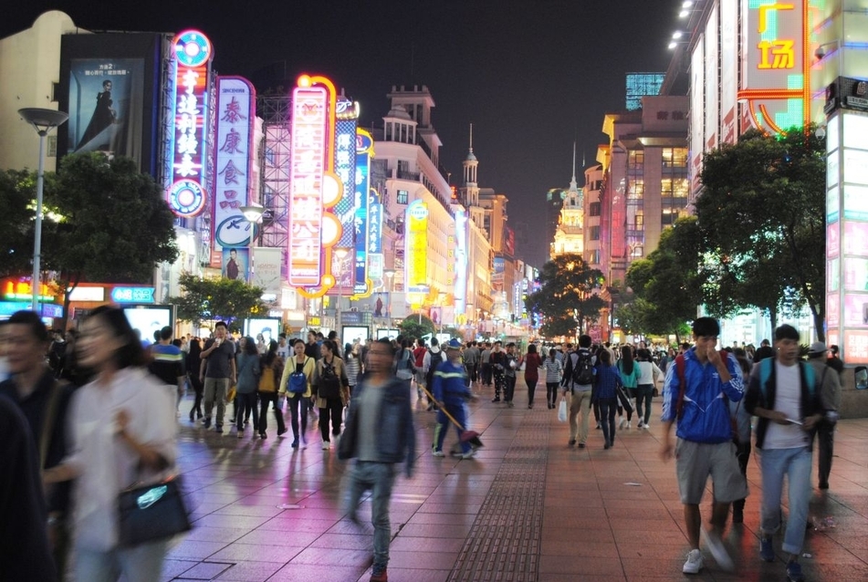 Nanjing road az esti forgatag idején. A gyalogos főutca homogén világa estére fények és reklámok hivalkodó kirakatává változik át, forrás: Gyergyák János