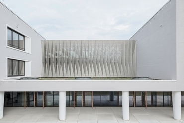 Nyugati homlokzati részlet a zenetermi kijárattal és az emeleti galéria perforált árnyékoló lamellafalával - Hessenwaldschule - építészek: Alexander Vohl, Camilo Hernandez - fotó: Brigida González