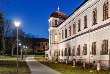 A tatai vártól a Kálvária-domb felé vezető vízparti sétány mentén, a városközponti épületek nagyságrendjébe illeszkedő, hivalkodástól mentes homlokzatával tűnik fel először a kastély az erre járók számára.