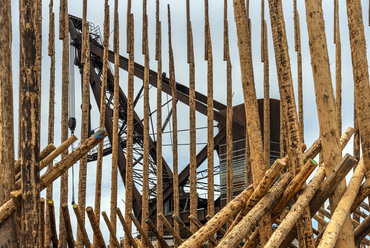A képen látható fa installáció a chilei-mapuche etnikai konfkliktusra hívja fel a figyelmet. Az installáció egyik tervezője a 2015-ös Biennálé főkurátora, Alejandro Aravena. 