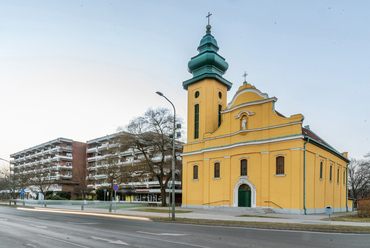 A „Sávház”, előtérben a neobarokk katolikus templommal. Érdekesség: Csepelen a Béke téri lakótelep szélén áll ennek az 1932-ben típustervként megépült templomnak egy másik példánya, de megtükrözött toronyállással. / Gulyás Attila, epiteszforum.hu