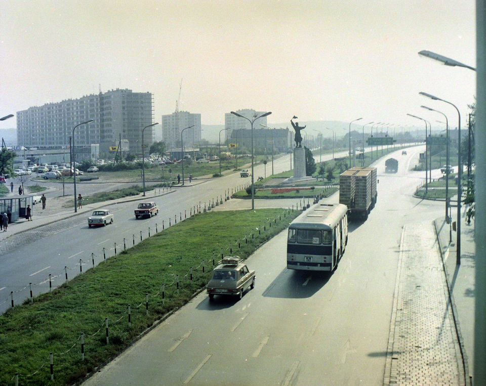 Budaörsi út, szemben az Osztapenko szobor a Balatoni út és az M1-M7 közös szakaszának találkozásánál. Balra az épülő Őrmezői lakótelep, 1975. Forrás: Fortepan / UVATERV