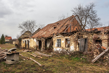 A főutca egyetlen, gazdátlannak tűnő házának romos falai láthatóvá teszik az építéskor használt hagyományos anyagokat, áthidalásokat.