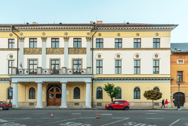 A klasszicista megyeháza a tér legfiatalabb épületeinek egyike, 1981-re készült el Povolny Antal tervei szerint.
