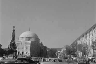 Széchenyi tér, balra a Szentháromság-szobor mögött a Dzsámi, jobbra a Nádor Szálló, 1956. Forrás: Fortepan / Inkey Tibor
