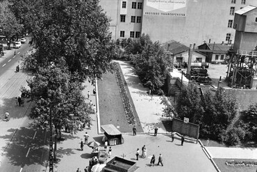 1961-ben a Nemzeti Színház bérházának teljes bontása utáni állapot, a közterületeken kialakított két hosszanti növénysávval. A saroktelken már a metróépítéshez szükséges eszközöket láthatjuk.

forrás: Fortepan / FŐMTERV
