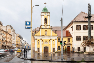 Messze a városközponti nagytemplom mögött, a 18. század eleji Pest első, városfalon kívüli temploma volt a Szent Rókus kápolna, az egykori pesti temető közepén.
