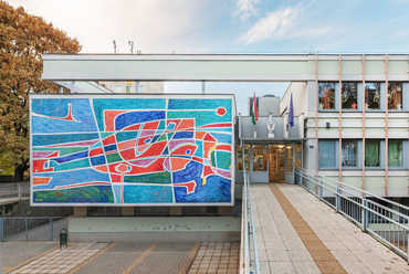 A ózdi Vasvár úti általános iskola északi épülete már bő másfél évtizede állt, amikor az utcai főhomlokzatára felkerült Kádár György 48 négyzetméteres, Repülés című mozaikja.
