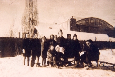Dunakeszi, szánkózó gyerekek csoportja 1947-ből, háttérben a Freund Dezső által tervezett Oceán konzervgyár épülete (Révész István Helytörténeti Gyűjtemény V/241.)  