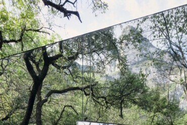 A Los Terrenos nyaraló falát alkotó üveg paneleken tükröződik az épületet körülvevő erdő. Forrás tatianabilbao.com