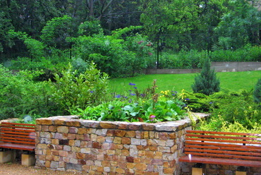 Terméskő növénykazetta a kert végében és a frissen telepített díszkert. Forrás: Garten Studio archívuma