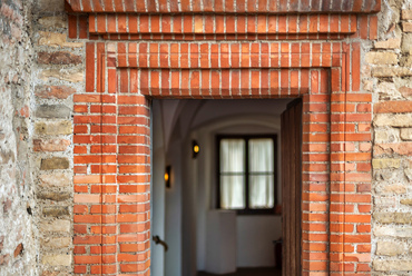 A faragott téglából rekonstruált egykori kő ajtókeret az első emeleti loggia kijáratán. 