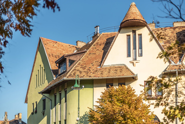 A Kós Károly által meghatározott program jellegzetes elemei a magas tetőidomok és a fa művészi megmunkálása, melyhez a tér épületeit tervező többi építésznek is alkalmazkodnia kellett. 