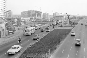 Budaörsi út, szemben az Osztapenko szobor a Balatoni út és az M1-M7 közös szakaszának találkozásánál. Balra az épülő Őrmezői lakótelep, 1976. Forrás: Fortepan / UVATERV