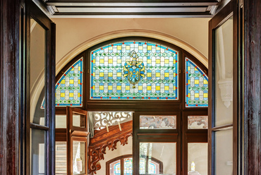 A megőrzött eredeti építészeti részletek egyik ékköve a lépcsőházból a Lovagterembe vezető nagy négyszárnyú ajtó színes üvegezésű lunettája, benne az Andrássy család címerével.
