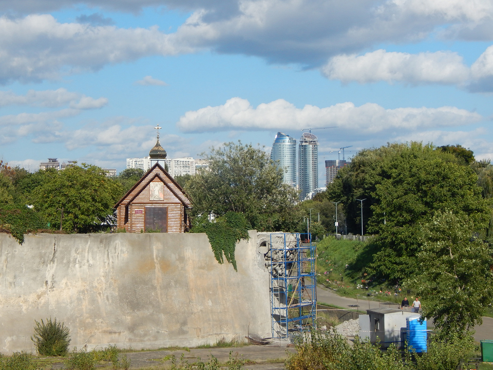 A támfal egy restaurált szakasza, felette a bajkovai temető ortodox kápolnája, háttérben a kijevi neoliberális városfejlesztés. Fotó: szerző fotója (2021)