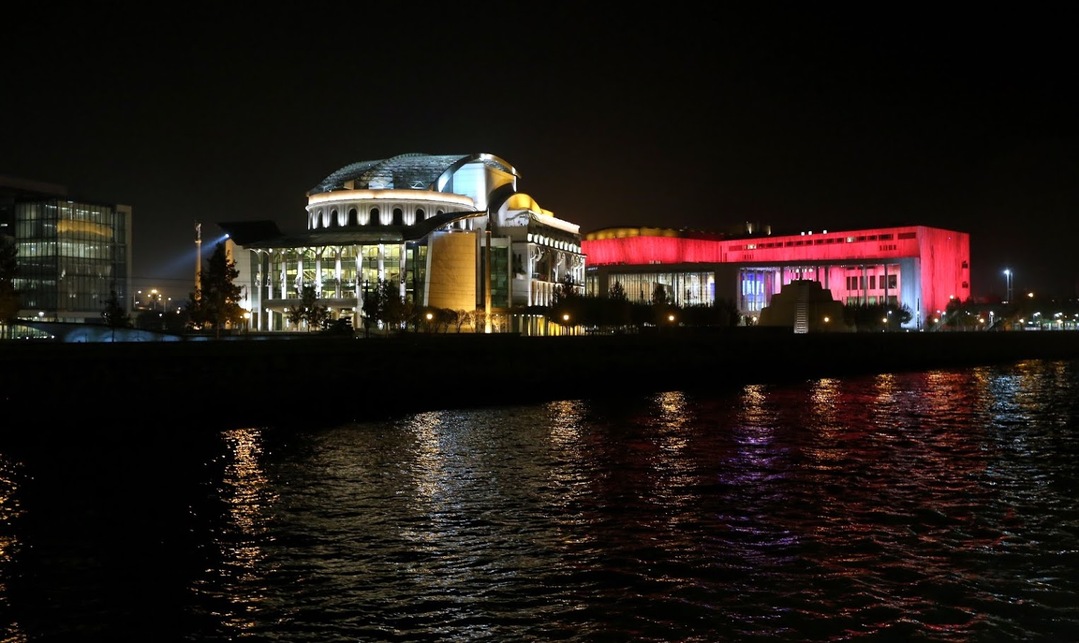 07 Müpa és a Nemzeti Színház díszkivilágításban a Duna felől, 2016. Forrás: Wikipedia