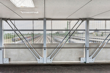 A híd peronos vágányok feletti nyílásai még lapos vasbeton lemezből állnak, a rá támaszkodó esővédő tetővel. A tehervágányok fölötti, nagyobb nyílásokban azonban a tető is teherviselő elem, a rácsos acélszerkezet felső öveként.