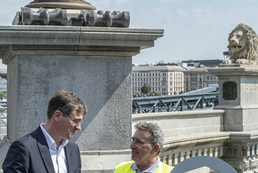 Karácsony Gergely főpolgármester (b) átadja a Lánchíd egyik csavarkulcsát Fazekas János hídmesternek a felújított híd átadásán a Lánchíd budai hídfőjénél 2023. augusztus 4-én.
