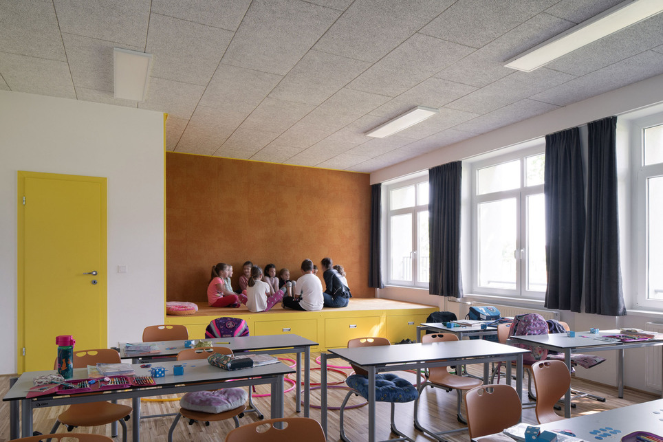 Az alsósok Sutos Tantermében a sut kiegészíti az iskolapadokkal berendezett osztálytermet: a kibélelt térbővület meseolvasásra, beszélgetésre, pihenésre vagy akár fekve tanulásra egyaránt jól használható. Fotó: Alex Shoots Buildings / Alexandra Timpau