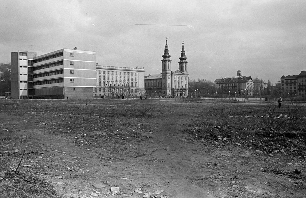 Szemben az 1938-ban felszentelt Szent Imre plébániatemplom, tőle balra a Budai Ciszterci Szent Imre Gimnázium, előtte részben a kísérleti lakóépület déli oldala és lépcsőházának tömege a Diószegi út felől, az előtérben pedig a később felépülő Sport-, majd Flamenco-szálló néven ismertté vált épület telke, 1960. Forrás: Fortepan / Belházy Miklós
