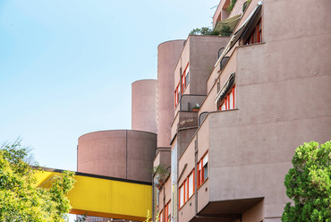 Az 1974-ben átadott beépítés, amely 5 épületben és összesen 440 lakásban közel 2500 embernek ad otthont, több mint 12 hektáron terül el. Ezek egyike Aldo Rossi ikonikus, mintegy 185 méter lakóháza is, azonban a projekt vezető tervezője nem ő, hanem Carlo Aymonino volt. Az általa jegyzett 4 lakóház expresszív építészeti formanyelve merőben eltér Rossi szikár racionalizmusától. Különböző elrendezésű, szintszámú és megközelítésű lakások helyezkednek el egymás alatt és felett, amely sokfélesége a házak tömegformálásában is megjelenik. Az épületek impozáns, de kietlen utcákat és tereket zárnak közre, amelyek az eredeti tervekben elgondolt közfunkciók hiányában leginkább Giorgio de Chirico szürrealista városképeire hasonlítanak.
