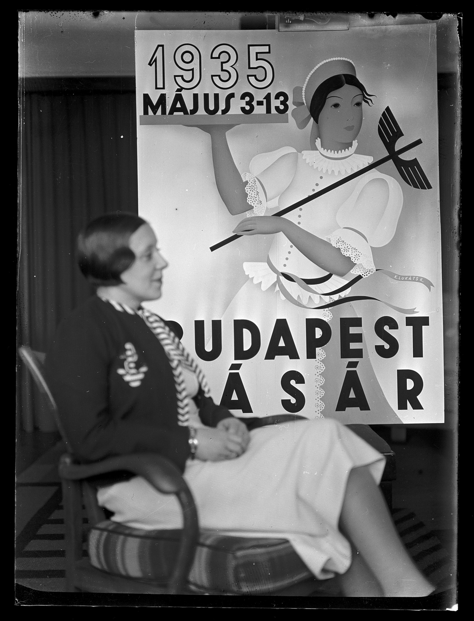 Lukáts Kató saját plakátterve előtt ül a Krisztina körúti lakásukban. 1935 körül. MÉM MDK Fotótár
