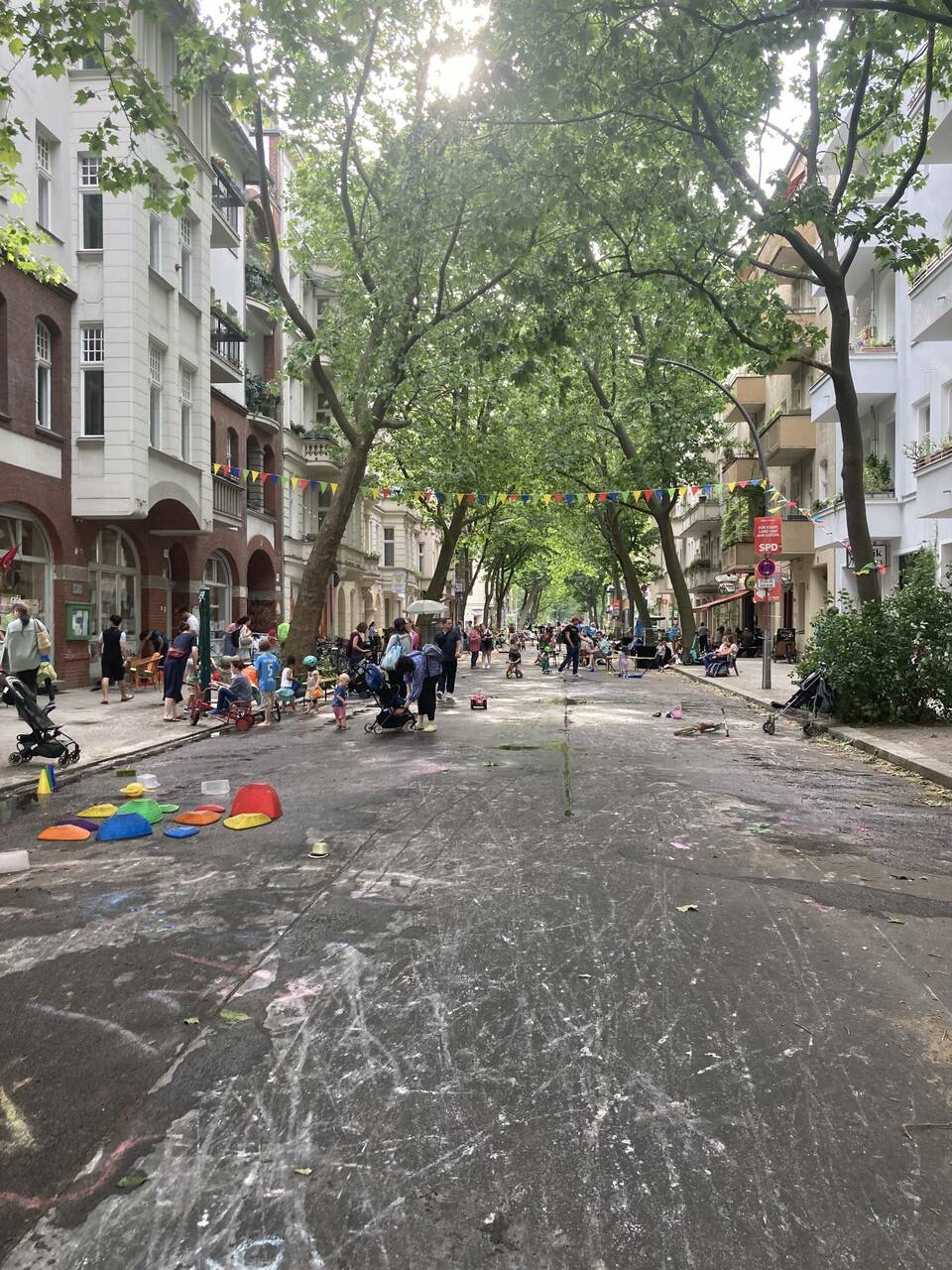 Játszóutca a berlini Schönebergben. A több mint 70 éve működő kiezoase szomszédsági központ és a környék lakói nyaranta, minden hónap harmadik keddjén játszóutcává alakítják a Barbarossasrtasse egy szakaszát. A berlini játszóutca kampányról bővebben: http://xn--spielstraen-36a.de/ Forrás: @jatszoutcakat__budapestre